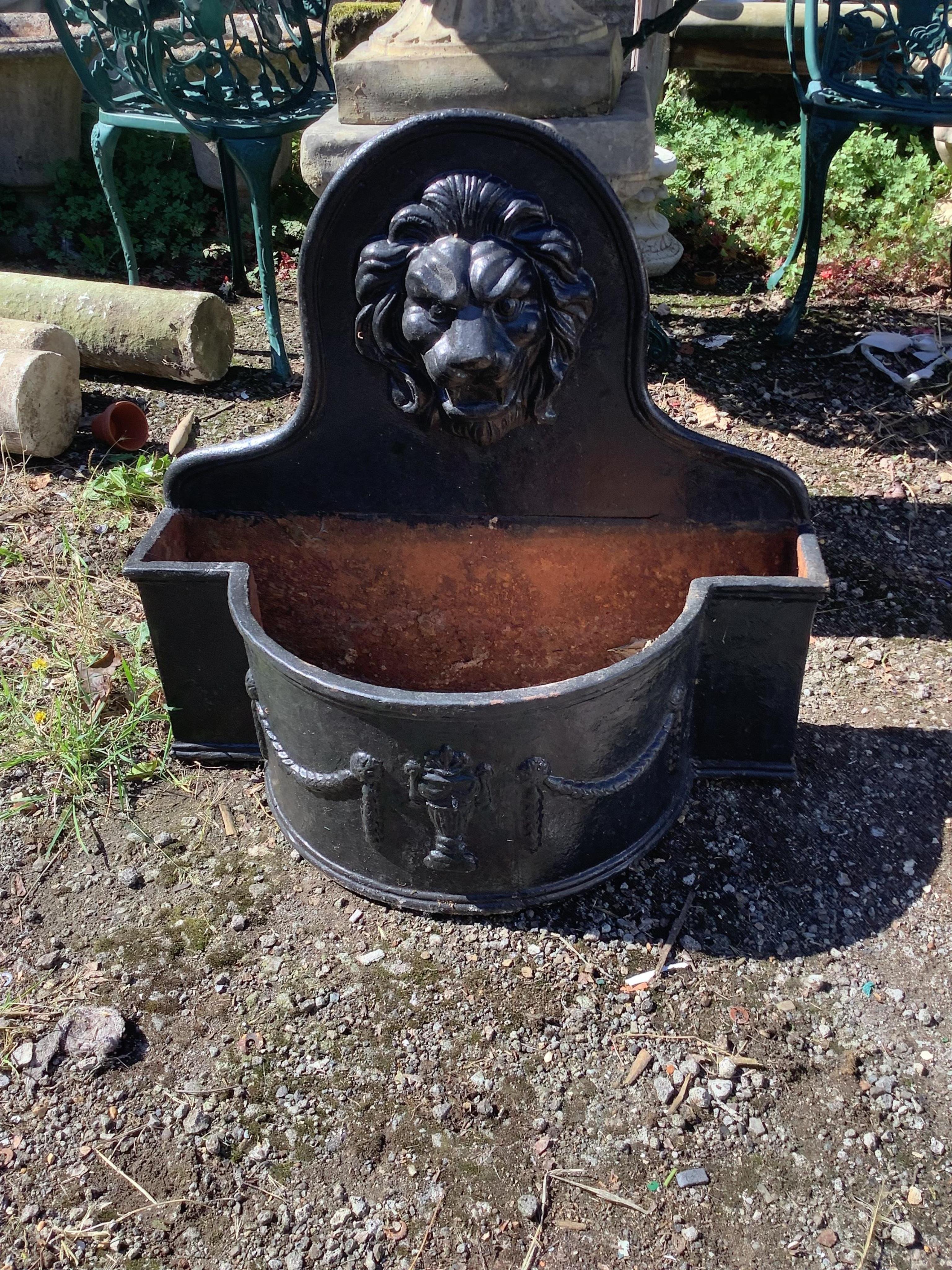 A pair of cast iron lion mask bowfront garden planters, width 69cm, height 65cm. Condition - fair